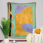 Couverture murale en tissu coloré avec des formes géométriques abstraites dans des tons pastel et vifs, créant une composition moderne et dynamique.