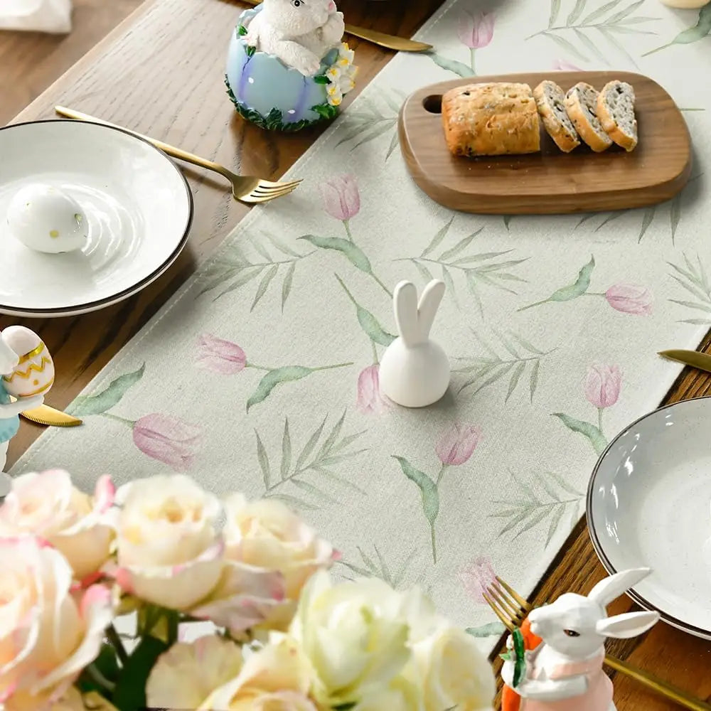 Une belle table de Pâques avec des décors floraux, des lapins en porcelaine et des délicieux pains dorés.
