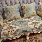 Une magnifique chaise en velours gris avec des motifs floraux élégants en tons de beige, de bleu et de brun, ornée de détails dorés.