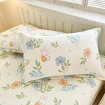 Draps de lit avec motifs floraux pastel et lapins mignons, donnant une atmosphère douce et agréable dans la chambre.