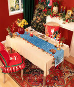 La pièce est décorée pour Noël, avec un magnifique sapin illuminé, des bougies allumées, et une table dressée avec de jolies décorations.