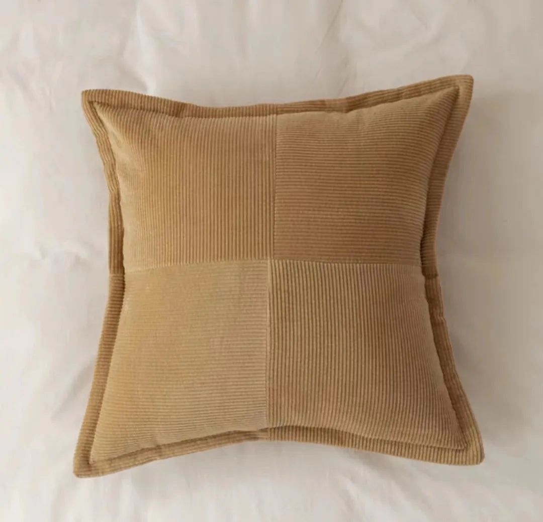 Ce coussin marron en velours côtelé apporte une touche de chaleur et de confort dans la chambre.