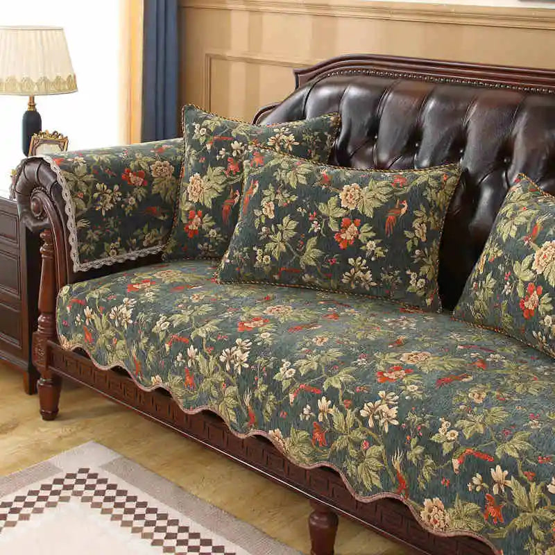 Un canapé ancien richement décoré de motifs floraux complexes et colorés, installé dans un salon élégant avec un lampadaire.