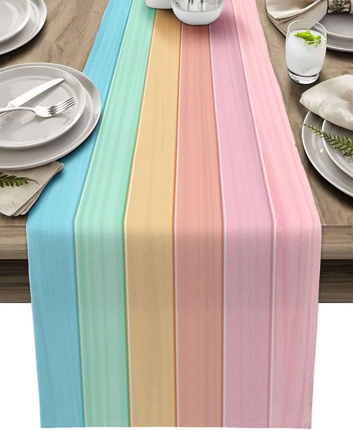 Un chemin de table coloré avec des bandes turquoises, jaunes et roses, créant une atmosphère chaleureuse et élégante pour une table joliment dressée.