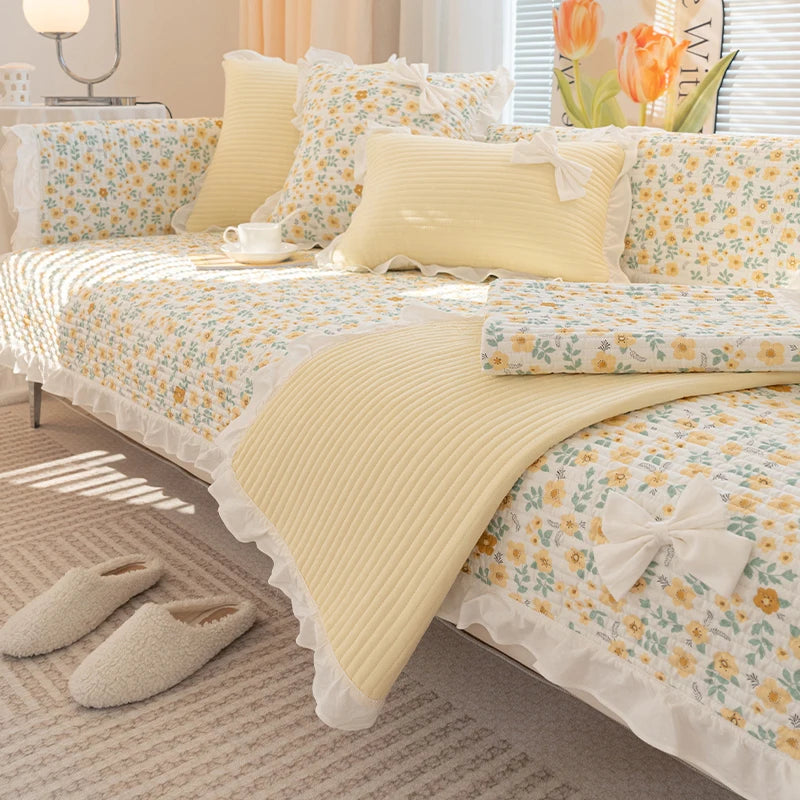 Douce et chaleureuse chambre aux teintes crème et florales, avec des coussins et une couverture en coton, reflétant un style cosy et romantique.