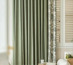 Vue d'ensemble d'un double rideau : un panneau vert uni et un panneau imprimé à motifs forestiers.