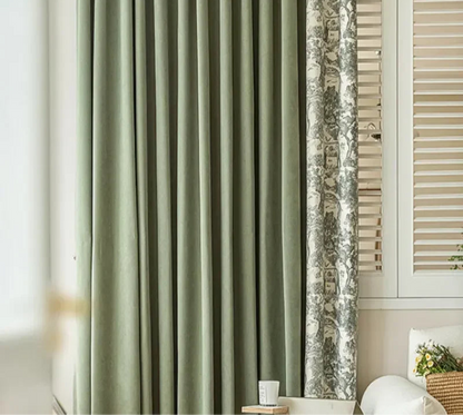 Vue d'ensemble d'un double rideau : un panneau vert uni et un panneau imprimé à motifs forestiers.