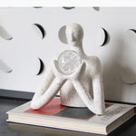 statue décorative personnage humain sphère transparente motifs internes neige cristaux blanc taches noires.texture granuleuse