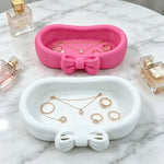 rangement bijoux rose blanc nœud papillon doux féminin surface lisse mat organisateur coiffeuse cosmétiques