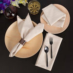 Une image élégante d'une table dressée avec une assiette, des serviettes en lin, des couverts et un verre de whisky, entourée de fleurs colorées.