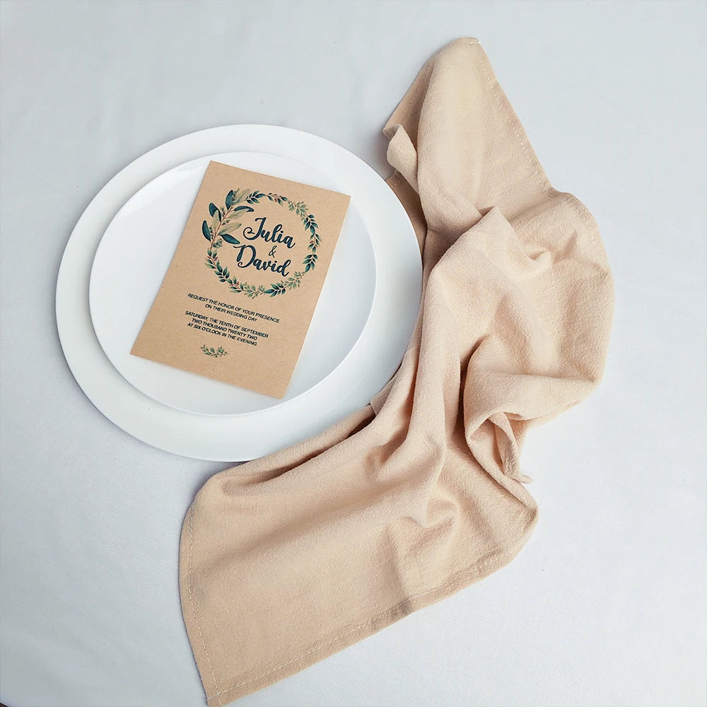 Une invitation de mariage sur un fond clair avec un tissu beige.
