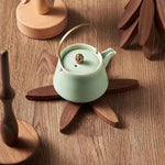 Dessous de plat en bois noir sur une table en bois, ambiance naturelle et élégante