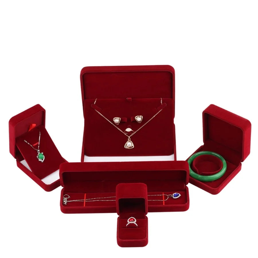 Boîte à bijoux en velours rouge violacé ouverte avec bijoux à l'intérieur
