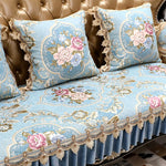 Élégant ensemble de coussins et de housse de canapé bleu pastel orné de délicates fleurs roses et beiges et de motifs baroques dorés.