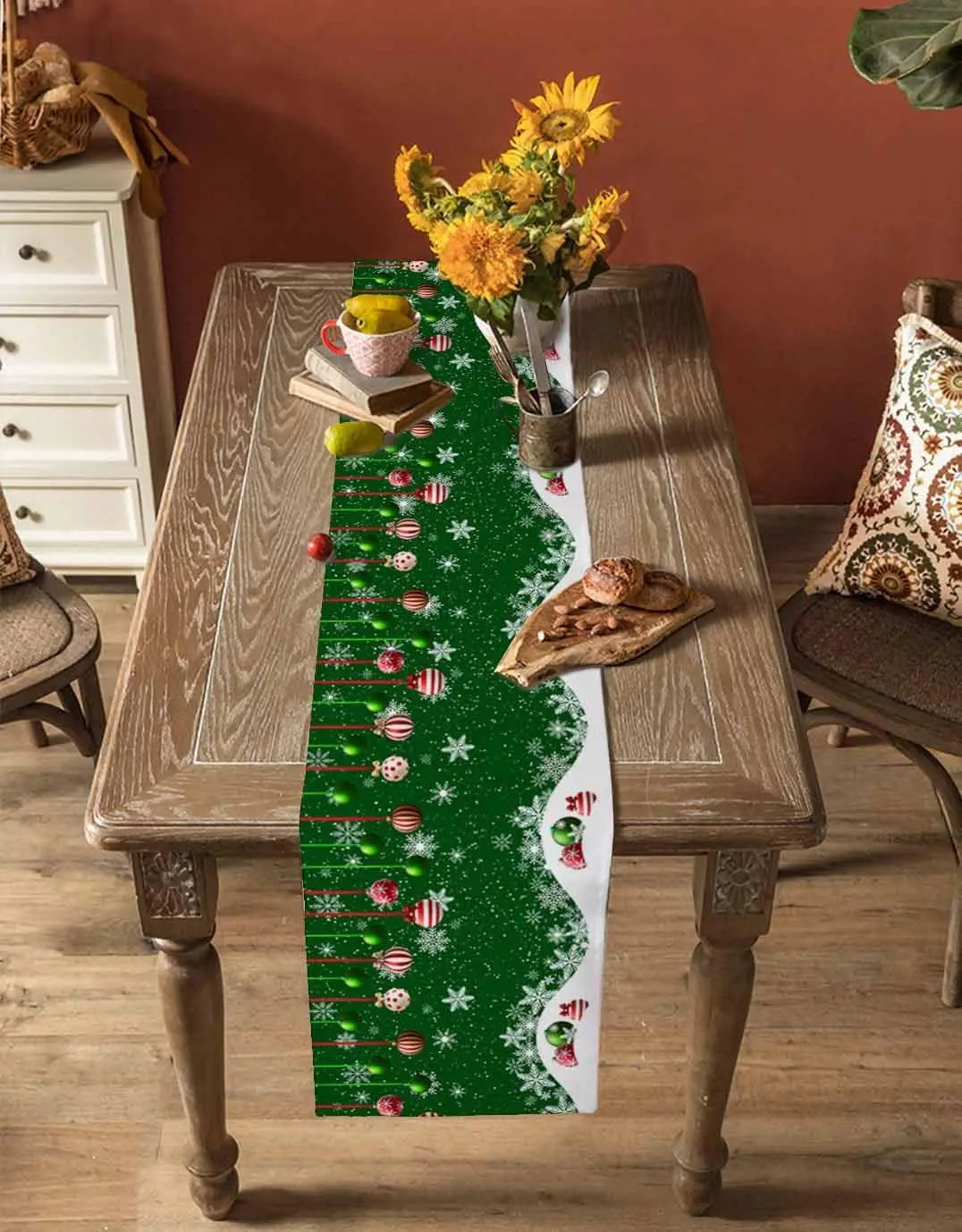 Une table rustique avec un chemin de table décoré de motifs de Noël, une bouquet de fleurs jaunes et d'autres objets décoratifs créant une ambiance chaleureuse et festive.