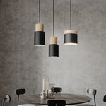 Lampe suspension noire éclairant un bar moderne avec ambiance chaleureuse