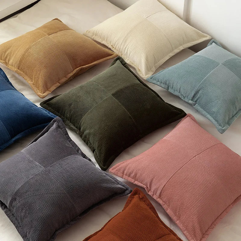 Une variété de coussins de différentes couleurs et textures, disposés de manière harmonieuse sur un lit, créant une atmosphère confortable et élégante.