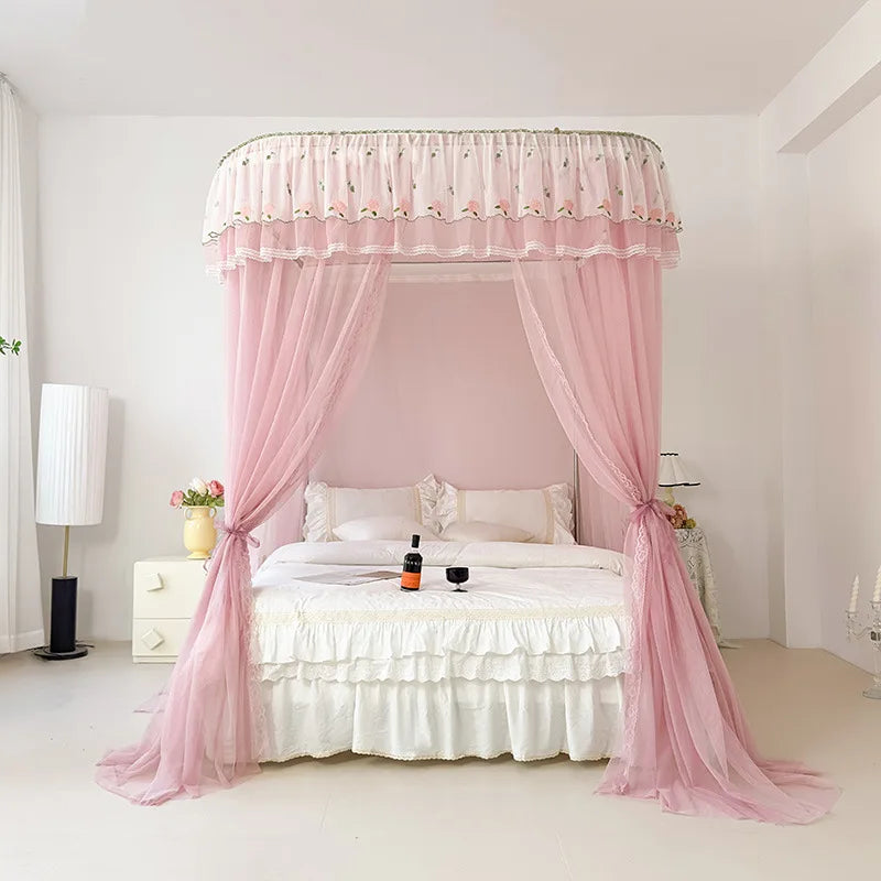 Un lit à baldaquin rose pâle orné de rideaux délicats dans une chambre blanche aux touches de décoration romantique.