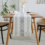 Élégante table à manger en bois avec un chemin de table décoratif et des accessoires de style scandinave.