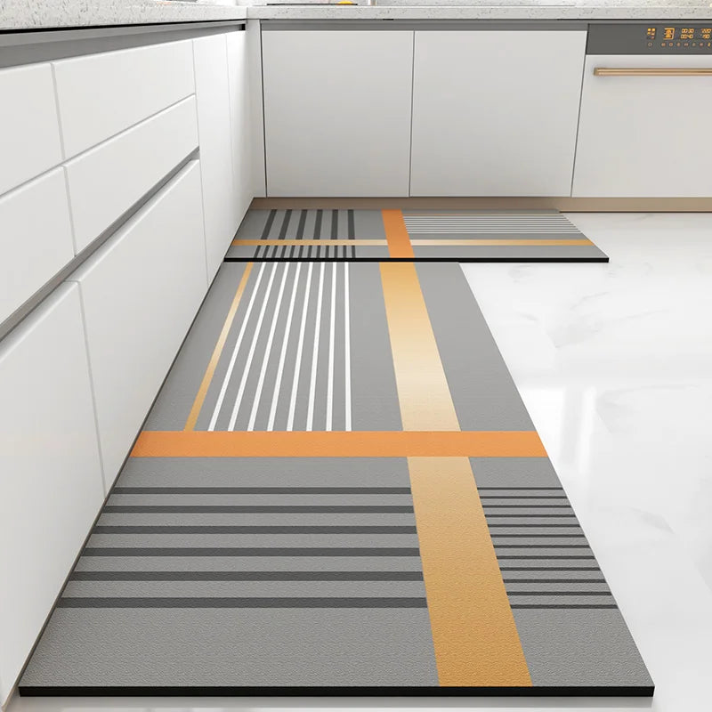 Motif géométrique abstrait aux lignes et bandes grises et orange, créant un design moderne et épuré pour un revêtement de sol dans une cuisine.