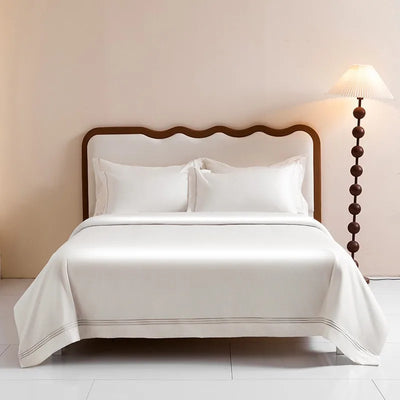 Housse de couette blanche 220x240 cm sur lit avec bordure brodée argentée