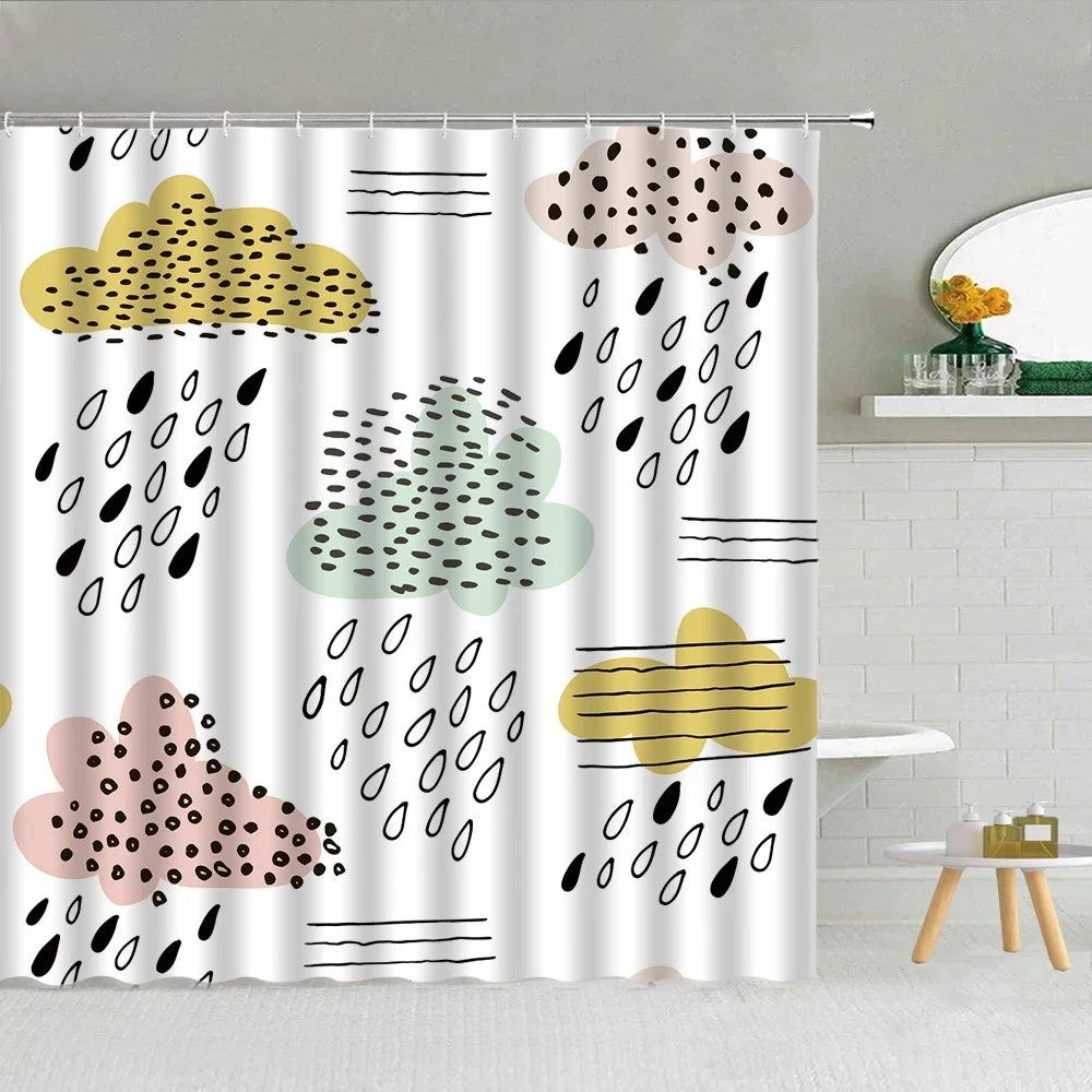 Rideau de douche avec un motif de nuages stylisés et gouttes de pluie sur un fond blanc. Les nuages sont dessinés dans des tons pastel de jaune, vert, beige et rose, avec des motifs de points noirs et de lignes. Des gouttes de pluie noires sont dispersées sur le rideau, ajoutant une touche graphique et moderne. Le rideau est suspendu à une tringle en métal et se trouve dans une salle de bain élégante, avec un miroir rond et une étagère décorée de fleurs jaunes.