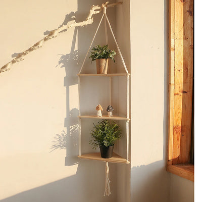 Étagère murale triangle macramé boho suspendue avec plantes vertes dans un salon