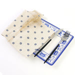 Un ensemble de table bleu et blanc avec une nappe et des accessoires pour le service, présentant un style rustique élégant et une décoration florale.
