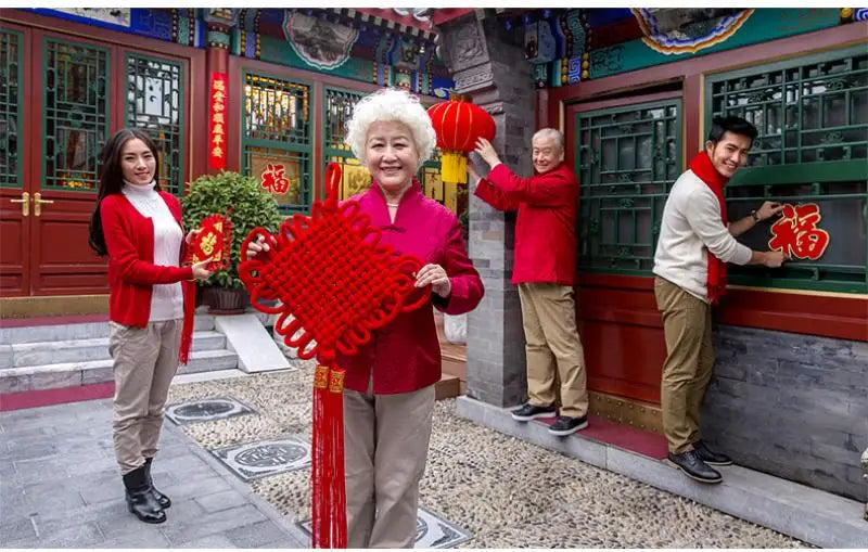 guirlande traditionnelle chinoise tissée artisanale rouge motifs géométriques pompon ruban doré festive printemps