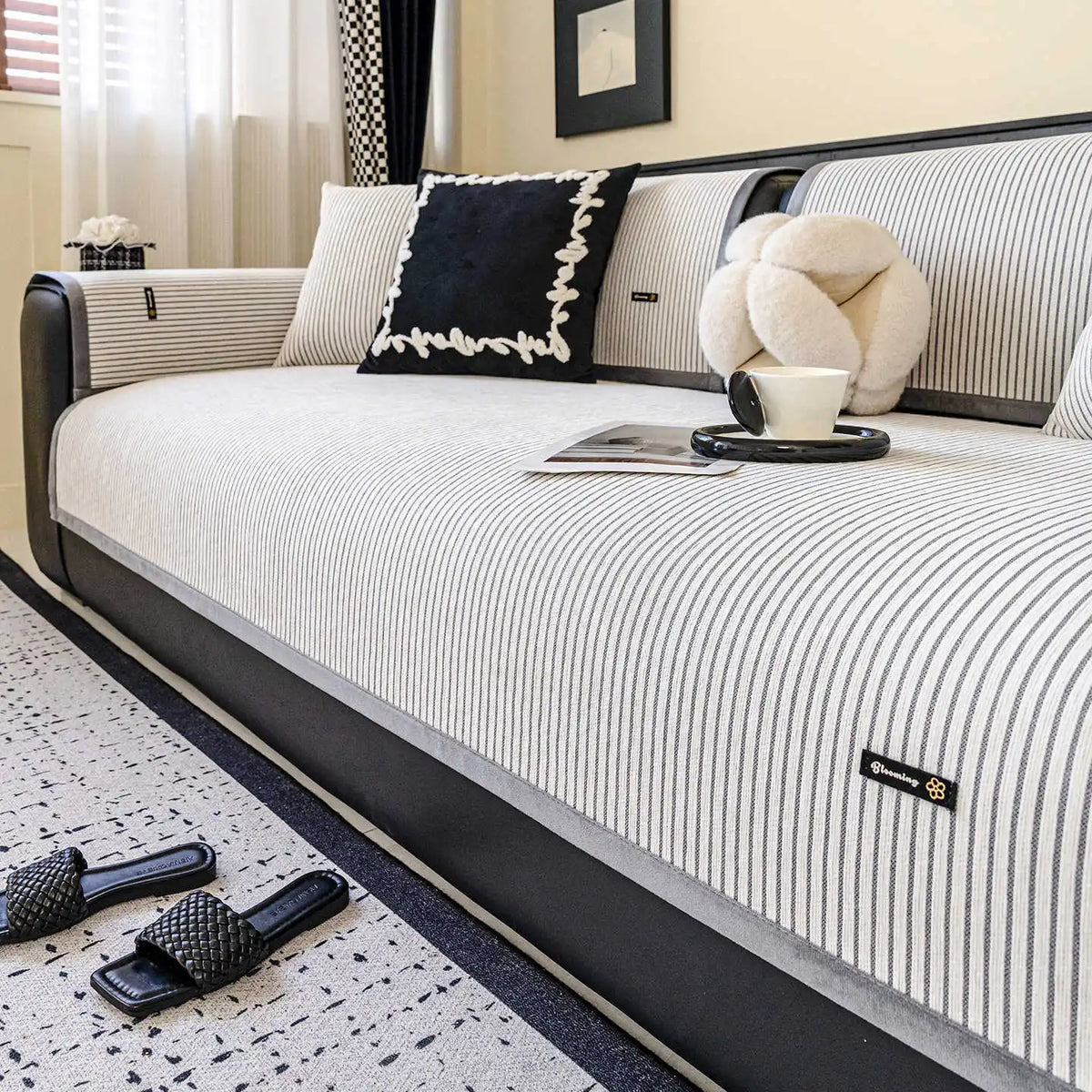 Une chambre moderne et épurée avec un lit confortable, des accents noirs et blancs, et quelques accessoires décoratifs.