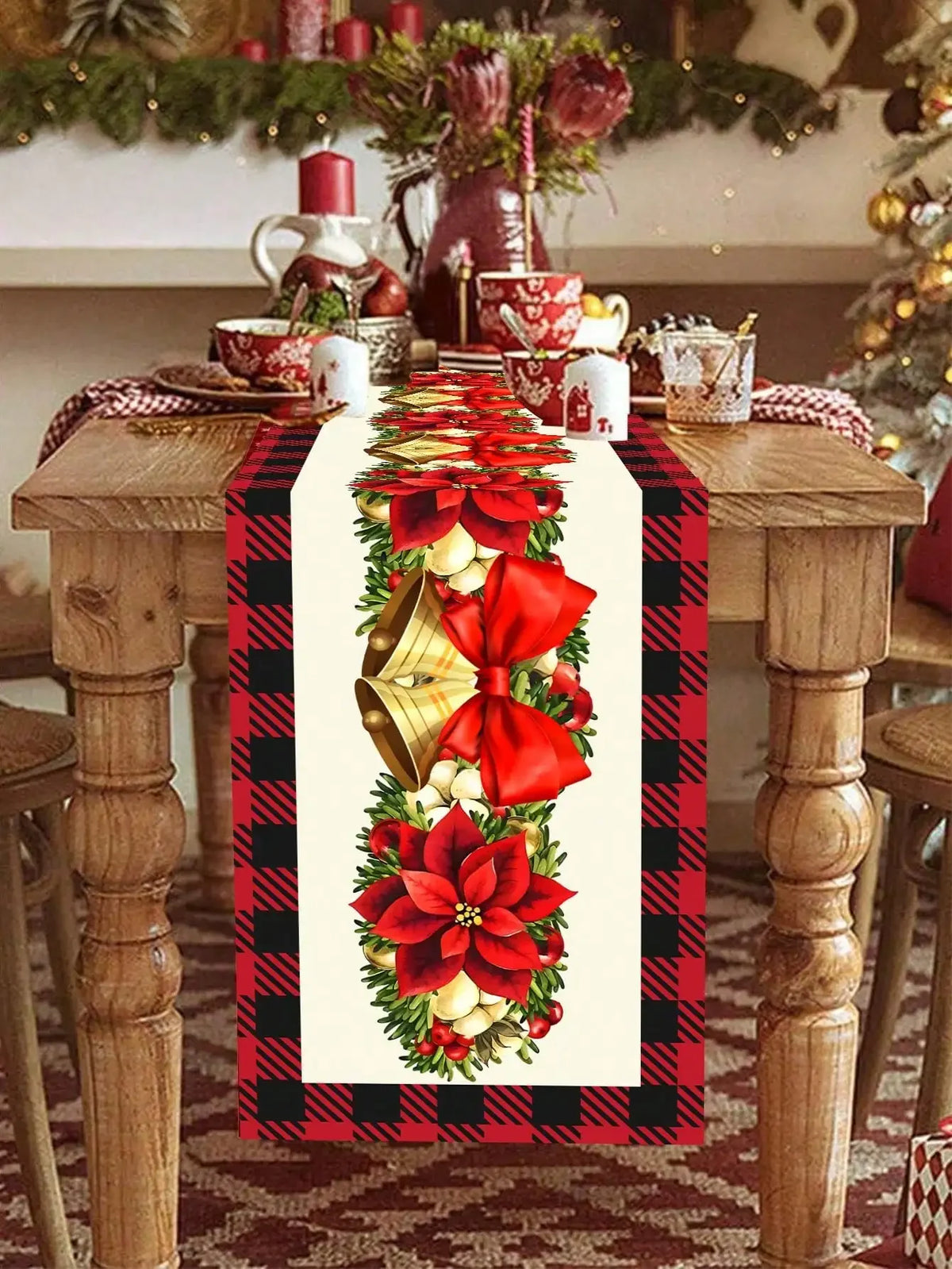 La table est magnifiquement décorée pour les fêtes de Noël, avec un magnifique centre de table décoré de fleurs rouges et de rubans dorés sur un chemin de table à carreaux rouges et noirs.