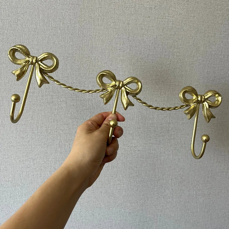 porte manteaux mural orné décoration rubans nœuds chaîne doré simple moderne fourreau crochets
