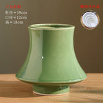 Vase en céramique de forme tronconique avec un fini brillant de couleur verte, mesurant environ 19 cm de diamètre et 18 cm de hauteur.