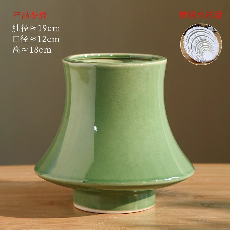 Vase en céramique de forme tronconique avec un fini brillant de couleur verte, mesurant environ 19 cm de diamètre et 18 cm de hauteur.
