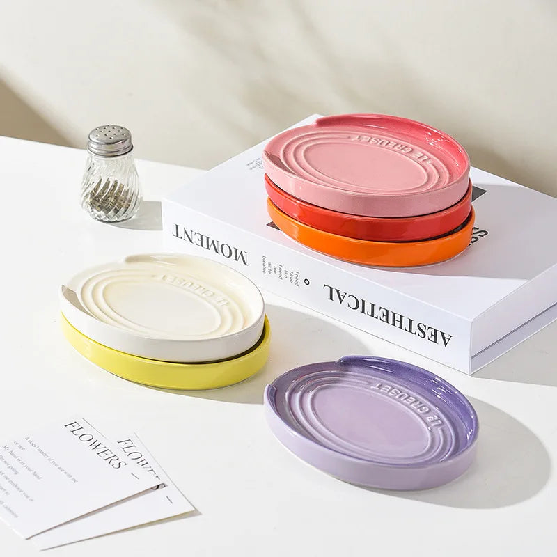Repose-cuillère rose avec ustensiles de cuisine placés dedans