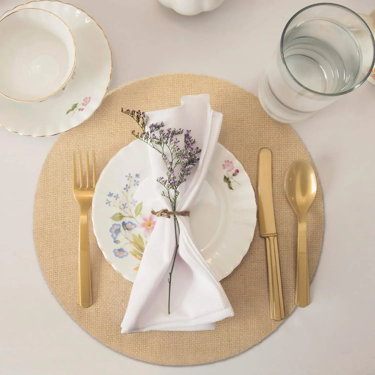 serviettes table beige feuilles artificielles rustique fourchettes dorées assiettes blanches vert classique decoration table