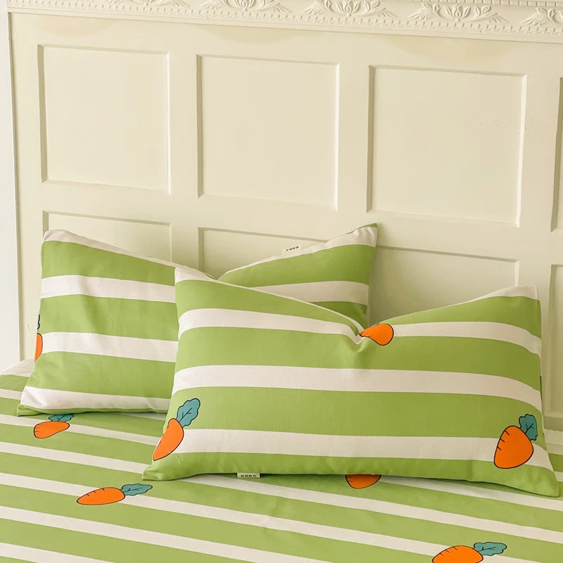 Ensemble de taies d'oreiller et de draps de lit vert et blanc avec motif de carottes, offrant une décoration de lit fraîche et ludique.