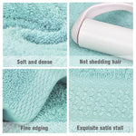 Serviette de bain coton uni de couleur gris clair dépliée dans une salle de bain moderne
