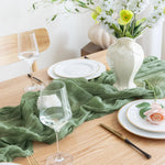 serviette table vert plissée moderne assiettes blanches verres vin bougies vase blanc pompons blancs