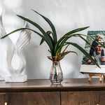 plantes artificielles vertes feuilles larges nervures dorées décoration intérieure moderne minimaliste pot verre support