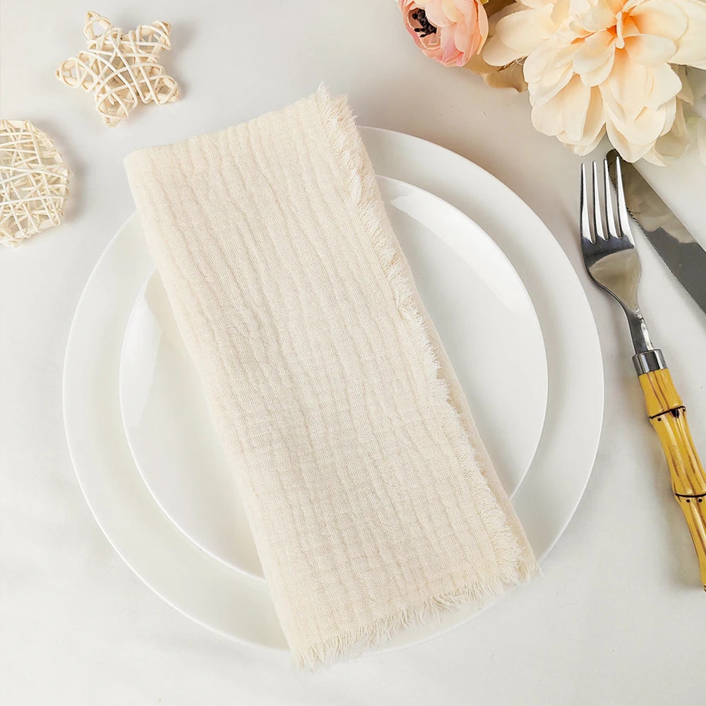 Un élégant arrangement de table avec une serviette à franges, une fourchette et un couteau ornementés, ainsi que de belles fleurs décoratives.