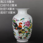 Vase en porcelaine décoré de motifs floraux colorés et d'un coq aux plumes éclatantes, représentant une scène naturelle.