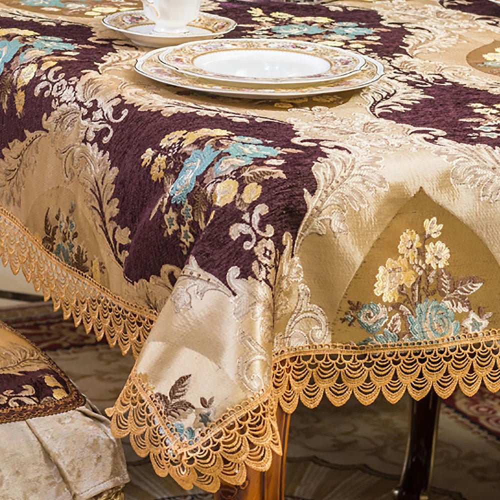 Élégante nappe de table ornée de motifs floraux dorés et de dentelle sur fond violet foncé, créant une ambiance chaleureuse et raffinée pour une réception.