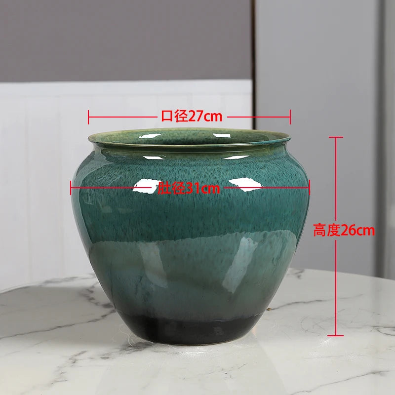 Pot en céramique de forme ronde de couleur verte avec des motifs, d'un diamètre de 27 cm et d'une hauteur de 26 cm.