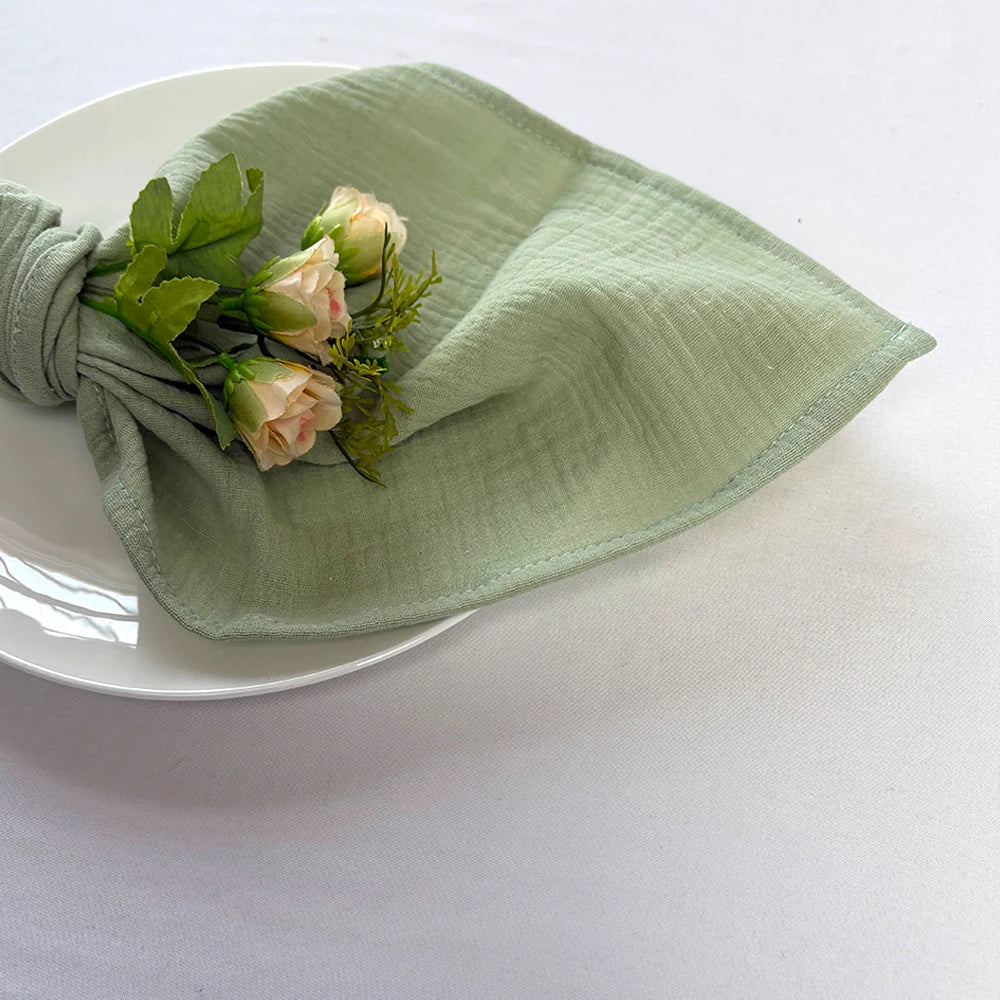 Un bouquet de roses délicates posé délicatement sur un linge de maison vert clair.