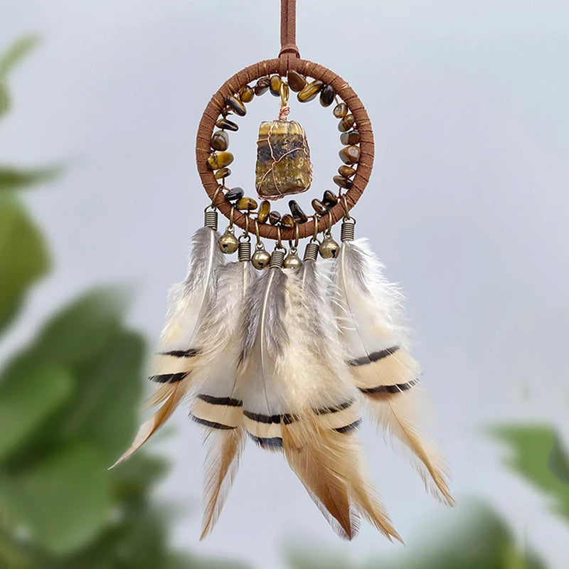 Attrape-rêves artisanal avec un cercle en osier, des perles décoratives et des plumes blanches et dorées, créant une œuvre d'art naturelle et apaisante.
