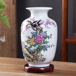 Un magnifique vase en porcelaine orné de fleurs colorées et d'oiseaux élégants, une pièce décorative raffinée qui apporte une touche de beauté et de sophistication à un intérieur.
