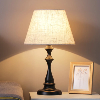 Lampe de chevet en fer et lin blanc sur table de nuit