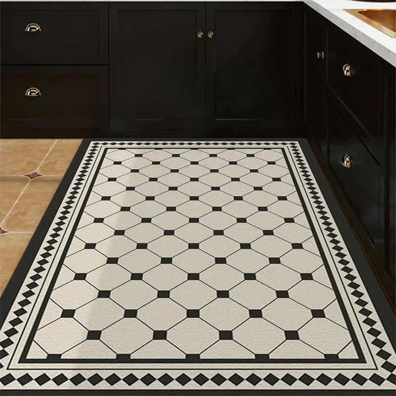 Carrelage de sol vintage à motif géométrique noir et blanc dans une cuisine avec des meubles de cuisine noirs.