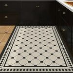 Carreaux de sol en damier noir et blanc, avec des motifs géométriques élégants, dans une cuisine aux meubles noirs.